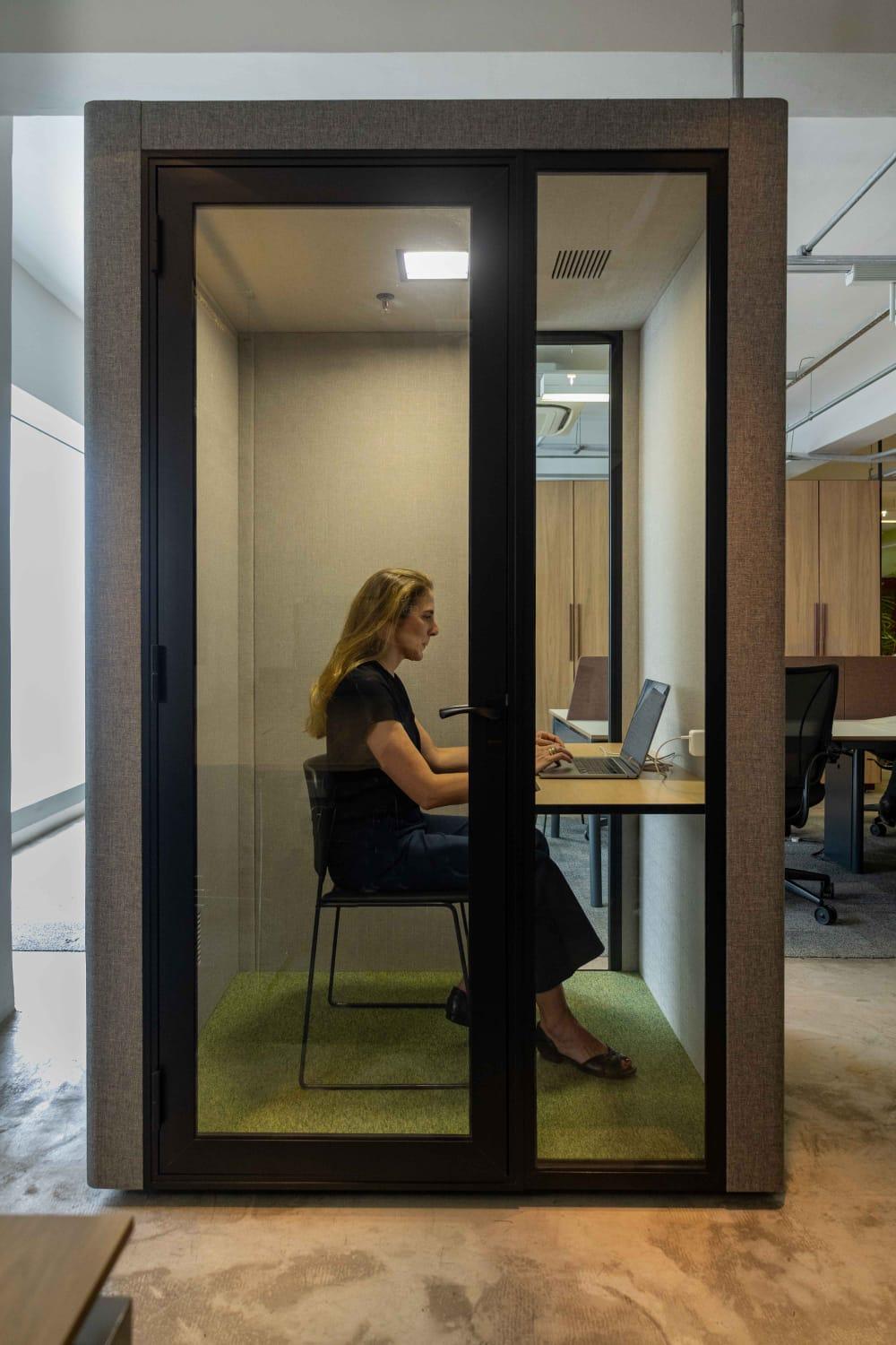 Cabine acústica Securit, que compõe a ambientação de um escritório.