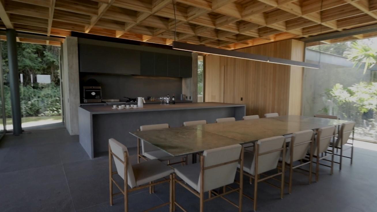 Espaço com mesa ampla, cadeiras confortáveis e churrasqueira, com ambientação relaxante da Securit.