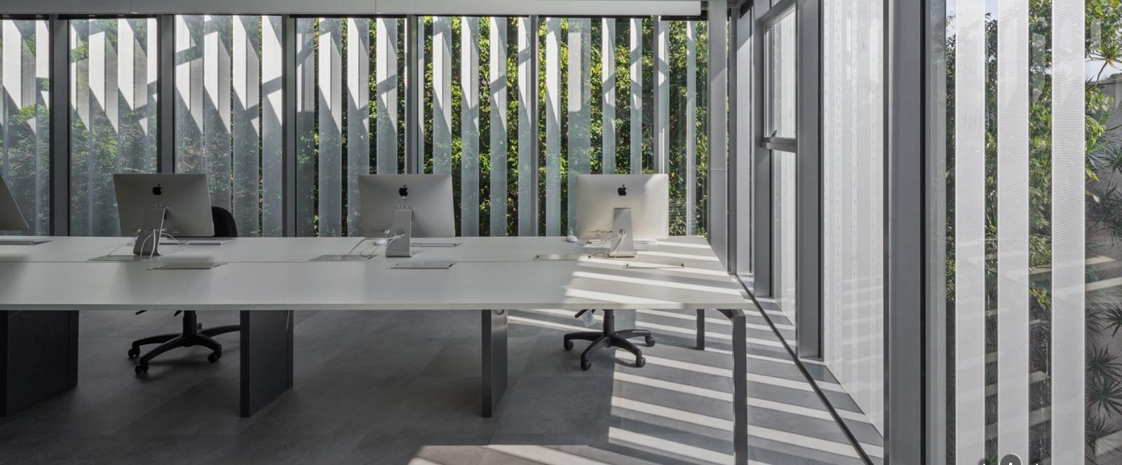 Mesa branca de escritório com computadores, representando as tendências de ambientação para 2026 da Securit.